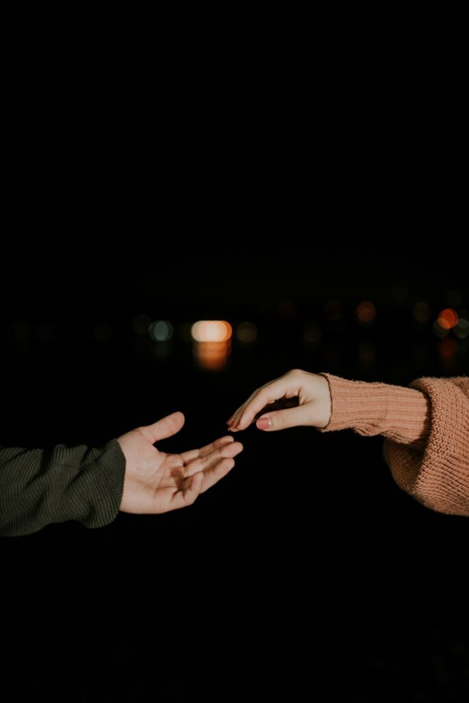 Two people reaching out their hands to each other