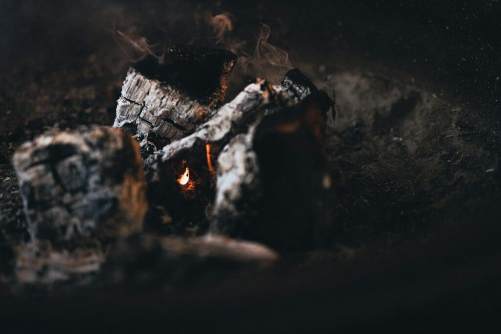 a close up of a campfire with smoke coming out of it