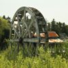 A wooden roller coaster in a field of tall grass